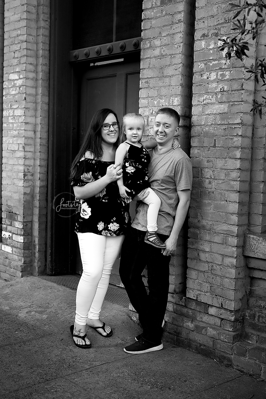 family posing by brick wall in downtown winters
