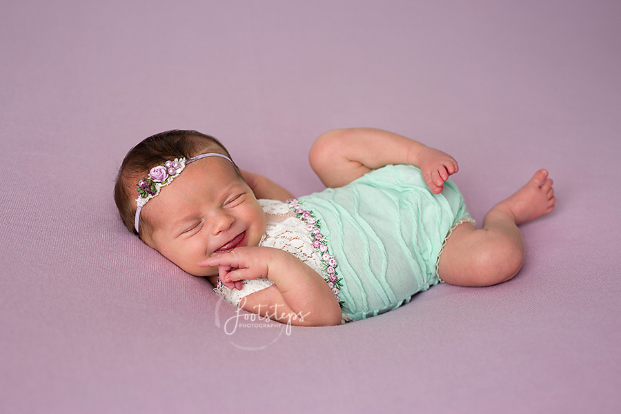 Smiling baby with cute aqua onesie